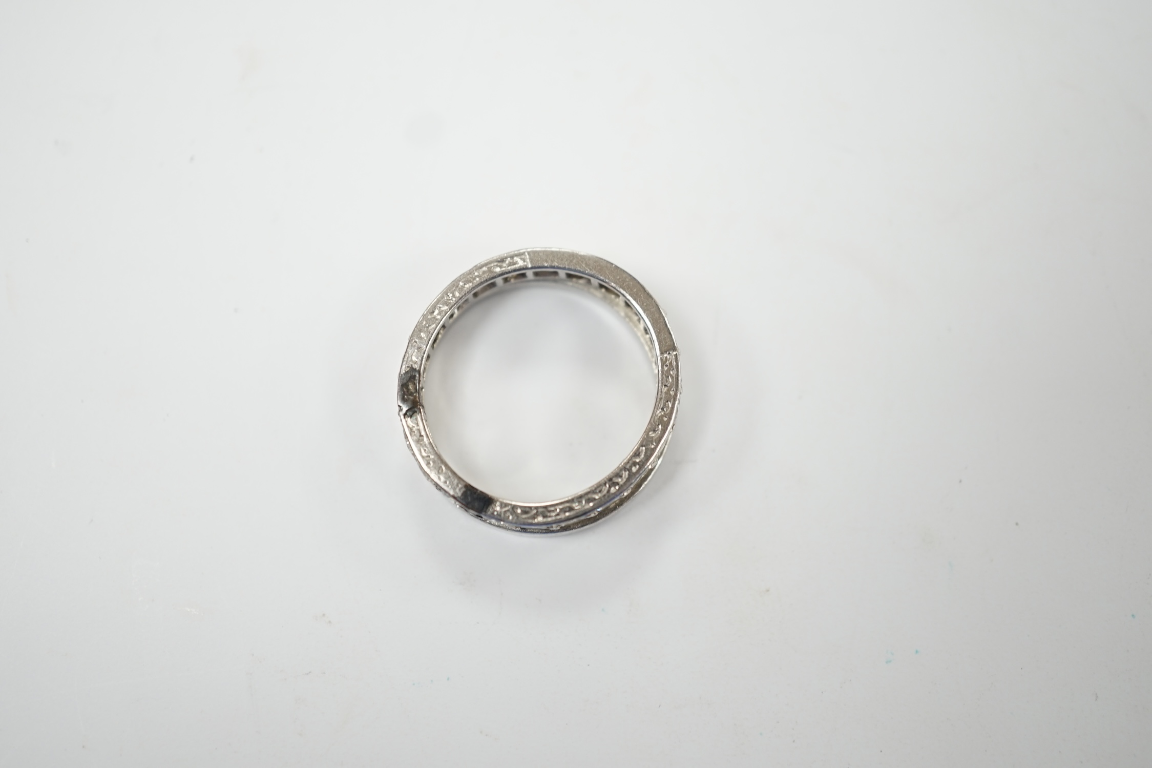 A white metal and diamond set full eternity ring, size K and an unmarked white metal band. Fair condition.